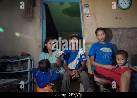 Portrait of a family living in the coastal neighborhood of Kamal Muara, Jakarta, as they wait for the head of their household back from work as a green mussel farm worker.   The village where they live is popularly known as the center of home industry for green mussel processing as a seafood product. This family says that they are also waiting for news regarding whether or not they will be forced to leave the area for the city's coastal development, the seawall and land reclamation megaproject. Archival photo (2008). Stock Photo
