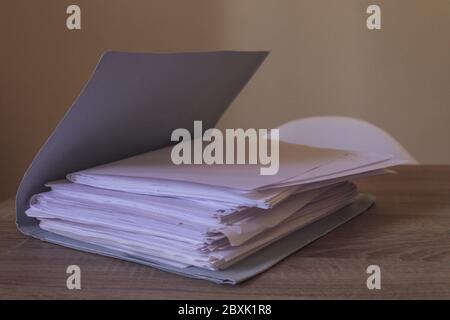 Stack of full file folder on a wooden desk with copy space Stock Photo