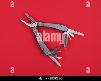 Multitool on a red background closeup. Stock Photo