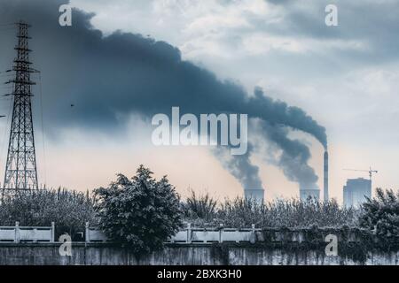 factory funnels with thick and black smoke Stock Photo