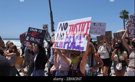 Oceanside, CA / USA - June 7, 2020: Protesters hold up a signs during a peaceful Black Lives Matter protest march in San Diego County.