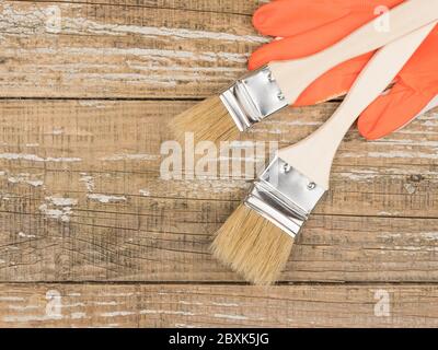 Radiator brushes and gloves on wooden background. Stock Photo