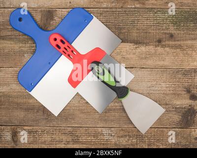 Painting spatula for repair work on wooden background. Stock Photo