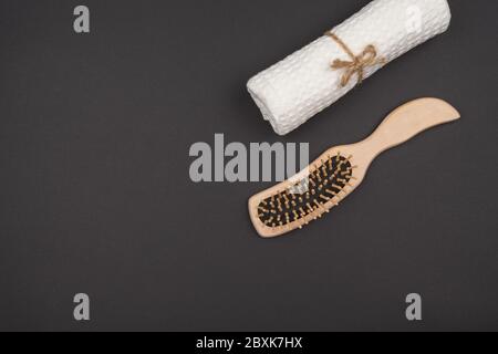 A comb and a towel roll on a black background. Stock Photo