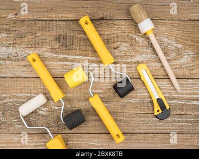 Closeup Photo Of Yellow Wallpaper Roller In Worker's Hand In White