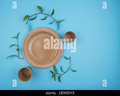 Paper disposable cups and plates on a blue background. Stock Photo