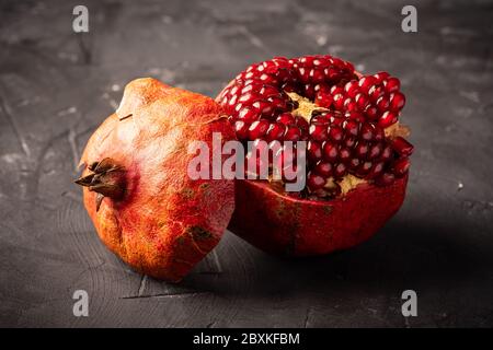 Fresh and delicious pomegranate on dark surface Stock Photo