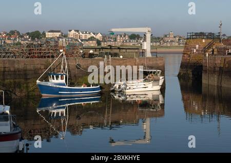 Boats reflecting in the water in the North Berwick harbor in Scotland Stock Photo