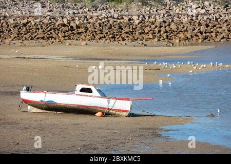 Small red fishing boat beached at Port Augusta, South Australia