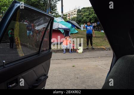 Members of 'Jesús Pescador de Hombres' foundation giving food aid to stranded Venezuelans in Cali. The organisation prepares and distributes hundreds Stock Photo