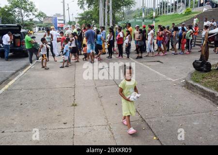 Members of 'Jesús Pescador de Hombres' foundation giving food aid to stranded Venezuelans in Cali. The organisation prepares and distributes hundreds Stock Photo