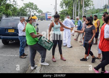 Members of 'Jesús Pescador de Hombres' foundation giving food aid to stranded Venezuelans in Cali. The organisation prepares and distributes hundreds Stock Photo