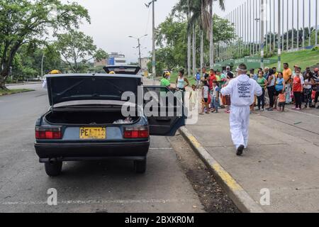 Members of 'Jesús Pescador de Hombres' foundation giving food aid to stranded Venezuelans in Cali. The organisation prepares and distributes hundreds Stock Photo