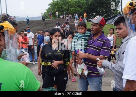 Members of 'Jesús Pescador de Hombres' foundation giving food aid to stranded Venezuelans in Cali. The organisation prepares and distributes hundreds Stock Photo