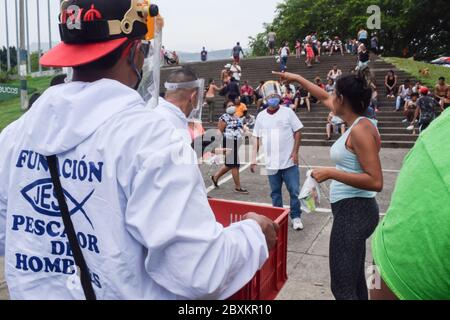 Members of 'Jesús Pescador de Hombres' foundation giving food aid to stranded Venezuelans in Cali. The organisation prepares and distributes hundreds Stock Photo