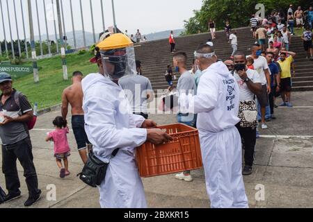 Members of 'Jesús Pescador de Hombres' foundation giving food aid to stranded Venezuelans in Cali. The organisation prepares and distributes hundreds Stock Photo