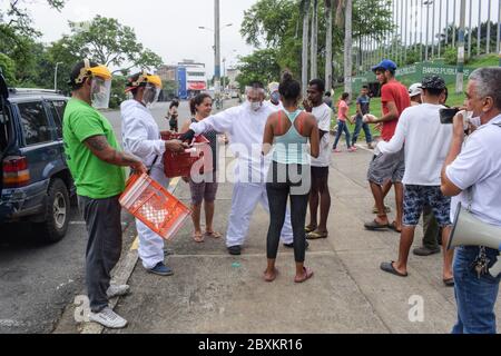 Members of 'Jesús Pescador de Hombres' foundation giving food aid to stranded Venezuelans in Cali. The organisation prepares and distributes hundreds Stock Photo