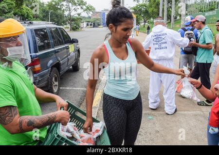 Members of 'Jesús Pescador de Hombres' foundation giving food aid to stranded Venezuelans in Cali. The organisation prepares and distributes hundreds Stock Photo