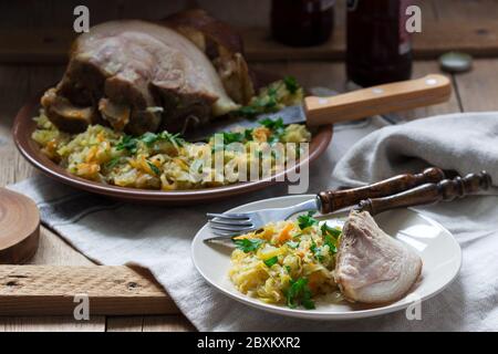 Baked pork knuckle served with stewed cabbage and beer. Rustic style. Stock Photo