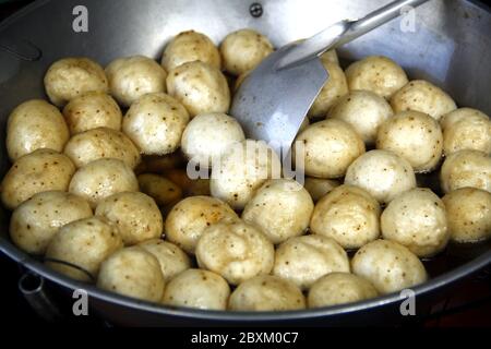 Photo of fish balls being deep fried in a pan. Stock Photo