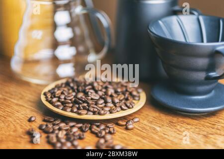 Closeup image of coffee bean and coffee drip set on wooden table Stock Photo
