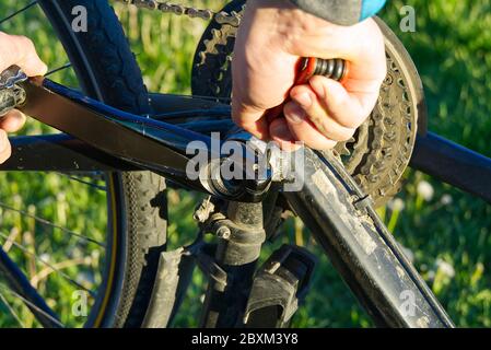 men repairing bicycle during bike trip. pedal bike repair outside close up Stock Photo