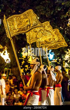 Golden Provincial Flags being carried through the streets of Kandy in Sri Lanka during the Esala Perahera (great procession). Stock Photo