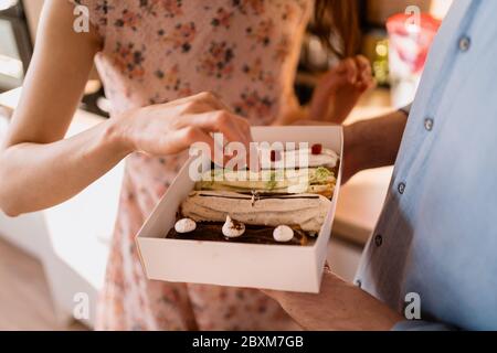 Young man with engagement ring making a proposal to his beloved girlfriend. The ring is in the eclairs Stock Photo