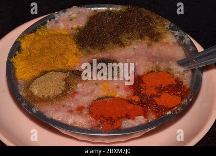 Various types of Indian spices or Masale kept on a steel plate which includes Turmeric Powder, Red Chili Powder, Ginger Garlic Onion Paste and Cinnamo Stock Photo