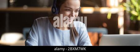 Woman wear headphones look at pc enjoy study with tutor Stock Photo