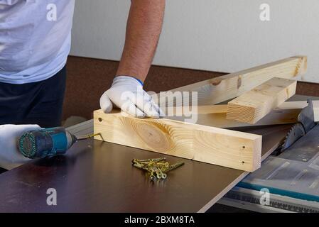 Closeup of professional cabinet makers working with electric circular saw at woodworking workshop. Wood material production. Lumber factory. Stock Photo