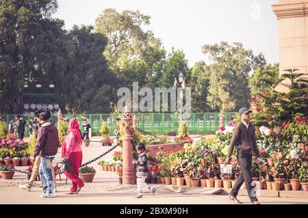 DELHI, INDIA - 05 FEB, 2014 - Indian people walking near India Gate in Delhi, India. Golden hour. Stock Photo