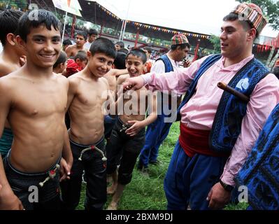 Young wrestlers greet a gypsy musician prior to the start of competition at the Kirkpinar Turkish Oil Wrestling Festival at Edirne in Turkey. Stock Photo