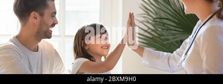 Little girl gives high five to female pediatrician during visit Stock Photo