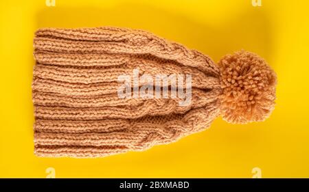 Handmade knitted winter hat on yellow background Stock Photo
