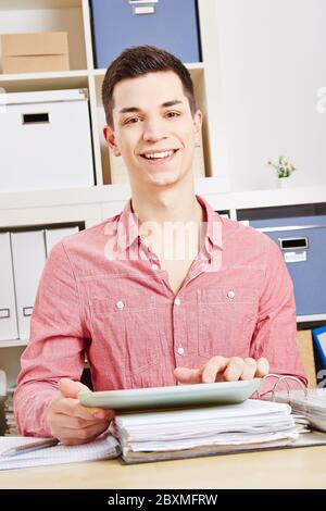 Young laughing man using tablet computer in the office Stock Photo