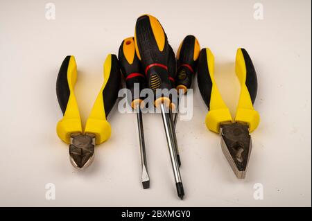 Different pliers and screwdrivers on a white background. Close up. Manual locksmith and installation tools for home work Stock Photo