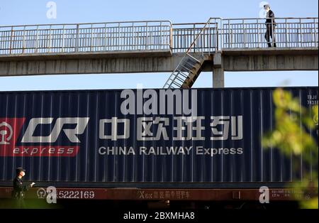 (200608) -- BEIJING, June 8, 2020 (Xinhua) -- A policeman checks an outbound China-Europe freight train at Horgos Pass in northwest China's Xinjiang Uygur Autonomous Region, April 20, 2020.  Initiated in 2011, the China-Europe rail transport service is considered a significant part of the Belt and Road Initiative to boost trade between China and countries participating in the program.  Amid the coronavirus pandemic, the service remained a reliable transportation channel as air, sea and road transportation have been severely affected. The freight trains have also been playing a crucial role in Stock Photo