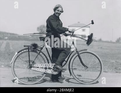 Chimney sweeper. A woman working as a chimney sweeper was not a common sight at this time in the 1940s. She is using her bicycle to transport herself and her equipment from house to house. Sweden 1940 Stock Photo