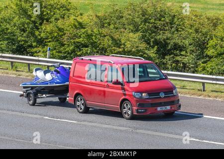 2018 red VW Volkswagen T-Porter T32 Highline TDI; towing Jet Ski trailer; Vehicular traffic moving vehicles, driving vehicle on UK roads, motors, motoring on the M6 motorway highway Stock Photo