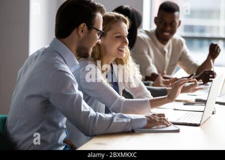 Colleagues working on common project prepare presentation using laptop Stock Photo