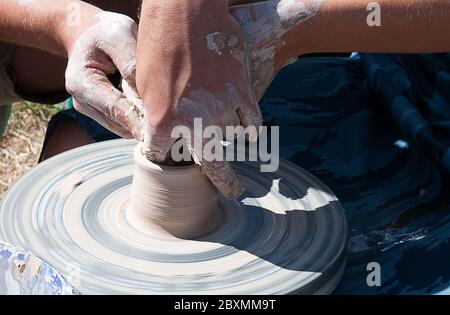 Master shows the student how to work on the potter's wheel Stock Photo