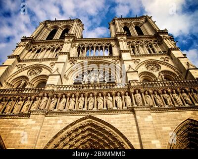 Majestic view of Notre Dame Cathedral showcasing intricate details and soaring towers under a vibrant sky in Paris, France Stock Photo