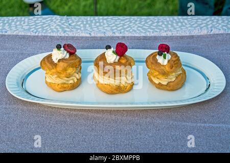 Three princess donuts on a plate with sweet fruit decorations on them. Stock Photo
