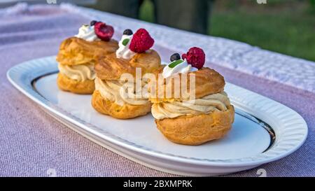 Three princess donuts on a plate with sweet fruit decorations on them. Stock Photo