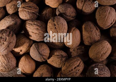 Autumnal rural frame with plenty of dry walnuts on an old wooden background. Stock Photo