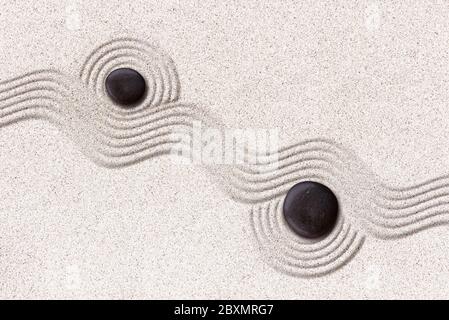 Zen raked sand and black stones japanese garden Stock Photo