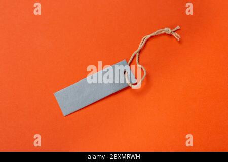 Blank tag tied with string. Price tag, gift tag, sale tag, address label isolated on green background. Stock Photo