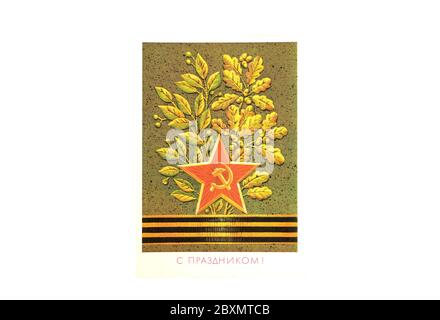 Moscow, Russia, June 07, 2020. Postcard of Soviet times with the image of a red star with a hammer and sickle, a St. George ribbon and oak leaves. Art Stock Photo