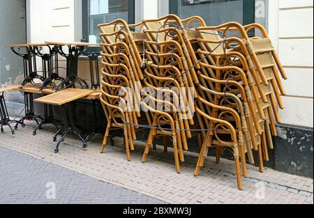 Stacked chairs and tables in front of a restaurant during the pandemic lockdown Stock Photo
